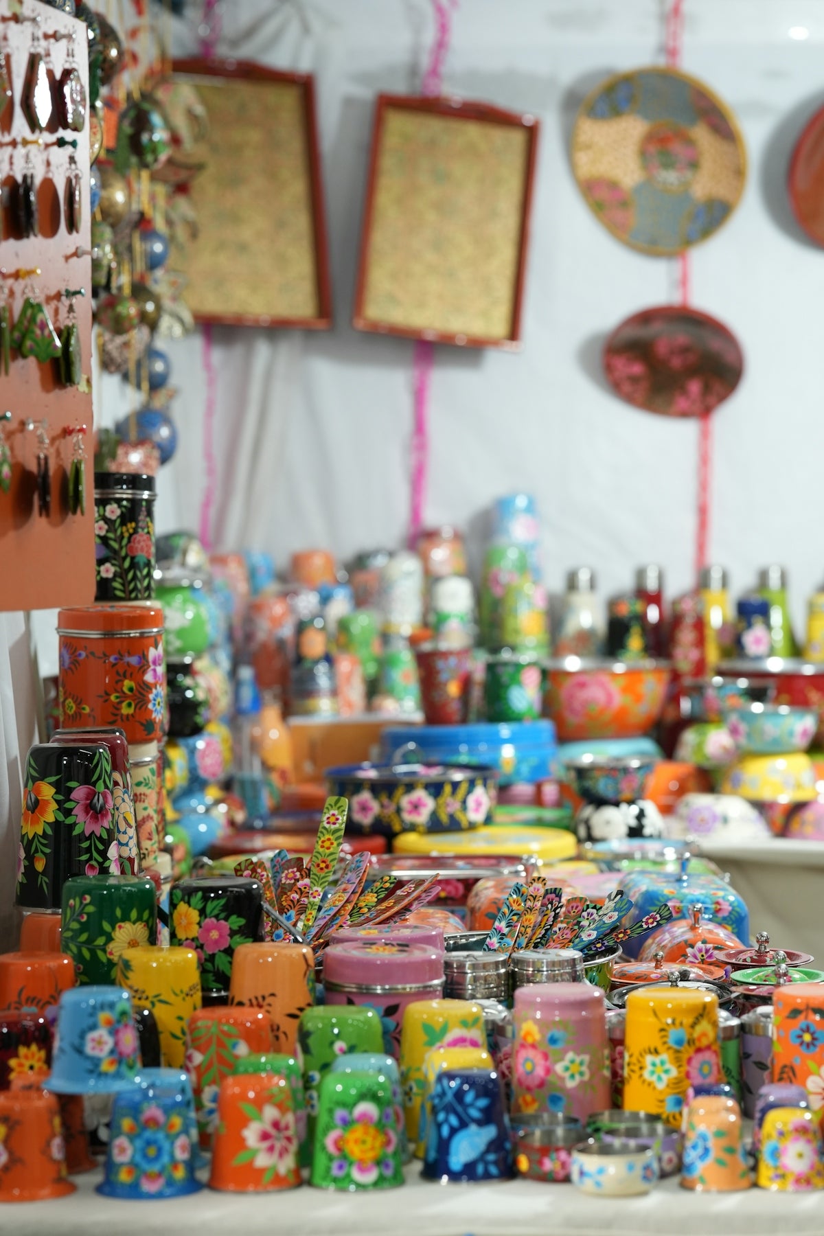 Colorful decorated containers and bowls displayed at a market.